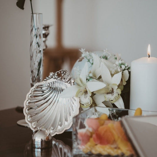 Concha de batismo em prata Topázio 1874 vieira com suporte decorativa junto a vela e flores