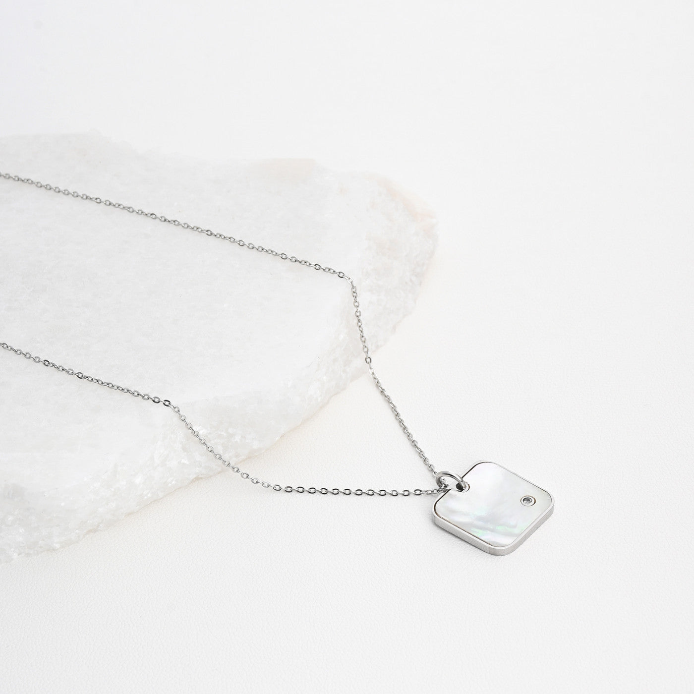 Square steel necklace with mother of pearl.