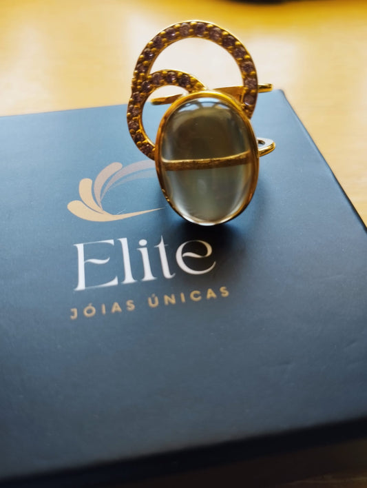 Anel dourado com pedra oval verde translucida sobre caixa Elite joia exclusiva Elite Anel Moon GreenGold