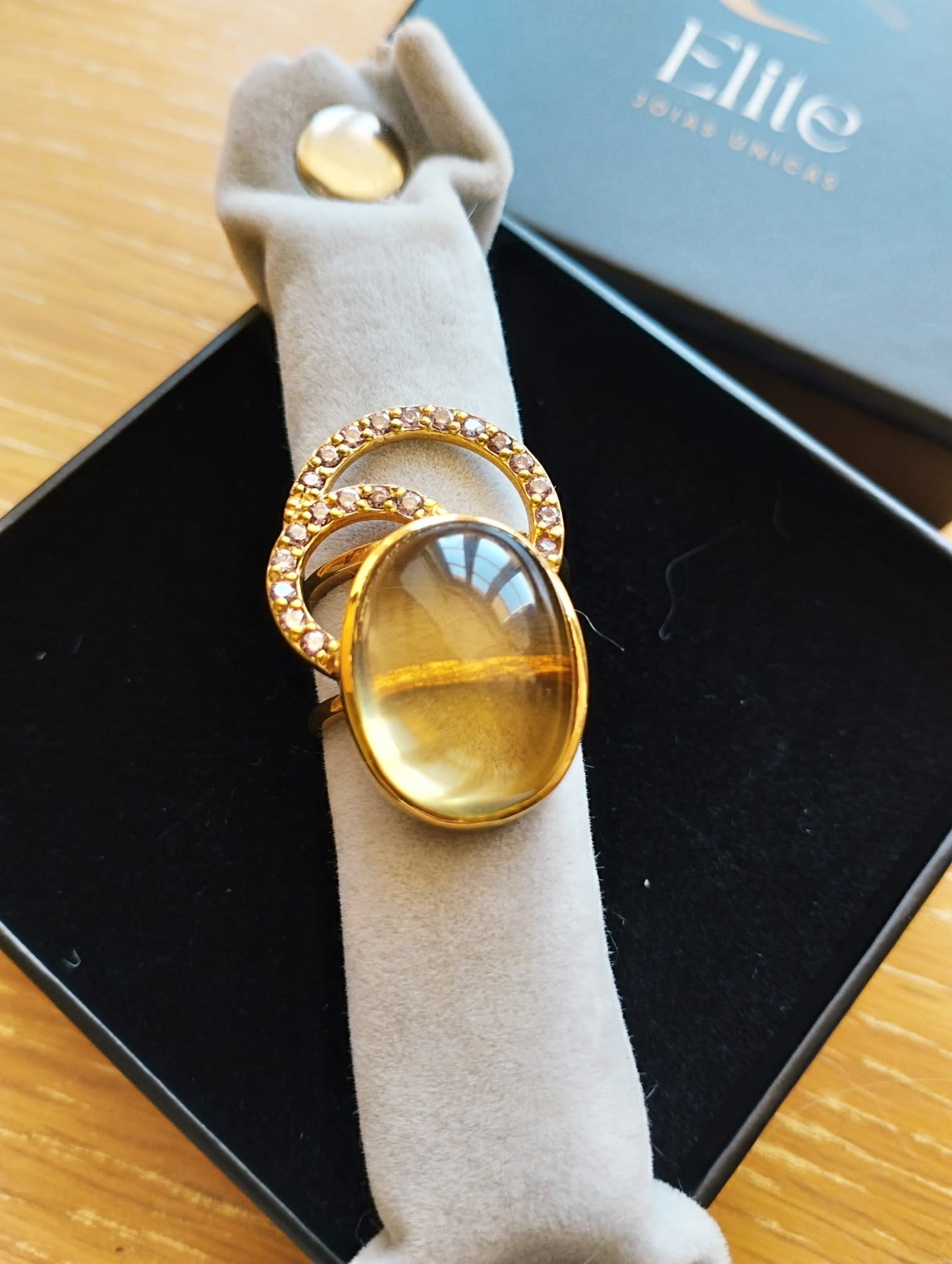 Anel ELITE dourado com pedra oval verde amarela e aro cravejado em estojo joia exclusiva Elite Anel Moon GreenGold